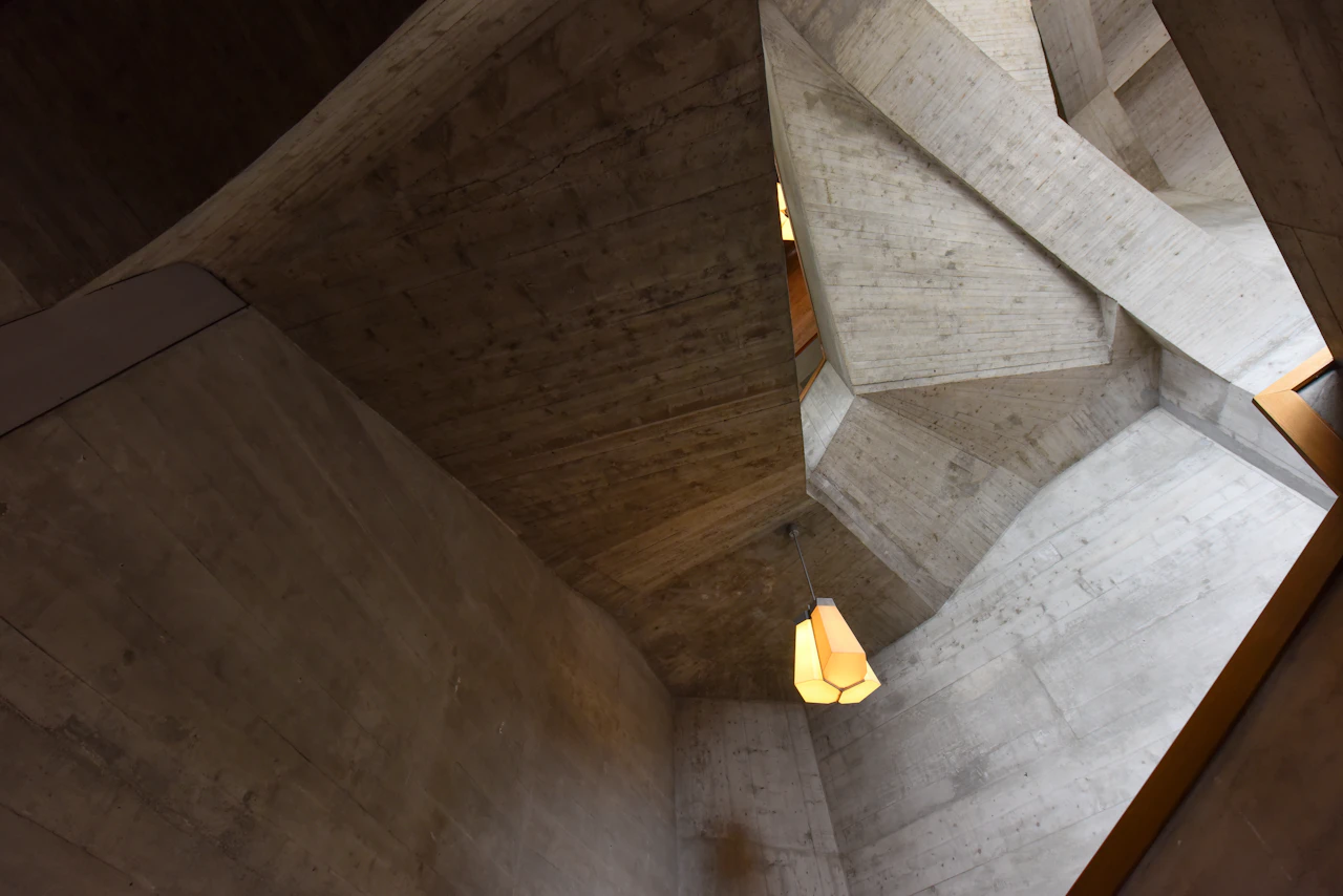 Atrium z betonu z ciepłymi lampami wiszącymi